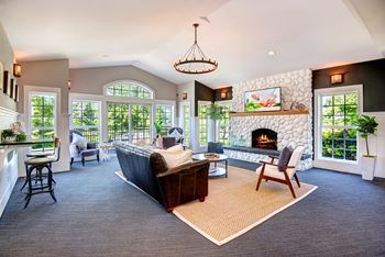a large living room with a stone fireplace and a couch at Deer Creek Apartments, Washington